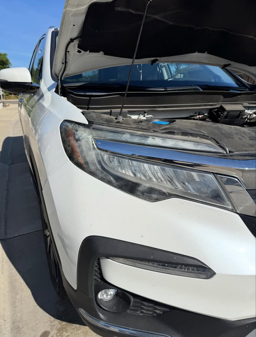 White Honda Pilot — headlight before restoration, hazed lens